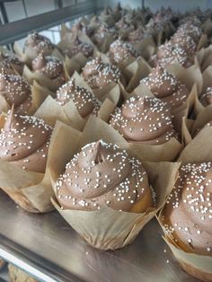 cupcakes with chocolate frosting and sprinkles on them are lined up