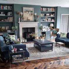 a living room filled with furniture and a fire place in the middle of a room