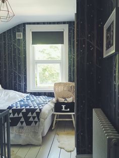 a bed room with a neatly made bed next to a radiator and a window