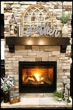 a fireplace with a sign that says gather above it and flowers in front of it