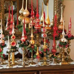 a table topped with lots of gold and red christmas decorations on top of it's sides