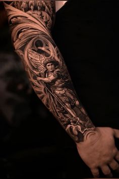 a man's arm with an angel and demon tattoo on the left forearm,