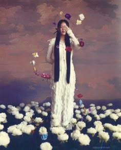 a woman standing in a field of flowers