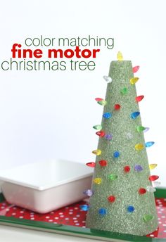 a green christmas tree sitting on top of a table next to a white plate and bowl