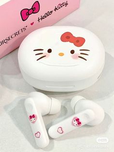 hello kitty earbuds are laying on the table next to a pink box with hearts