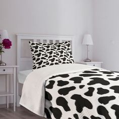 a black and white cow print comforter on a bed