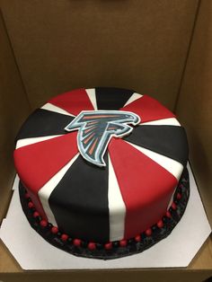 a cake in a box decorated with the atlanta falcons logo on it's side