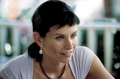 a woman sitting at a table with a plate of food in front of her and looking off to the side