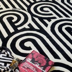 a black and white rug with a pink book on it