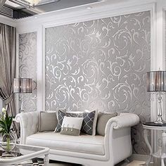 an elegant living room with white furniture and silver wallpaper