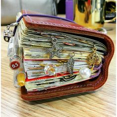 an open wallet sitting on top of a table filled with lots of cards and jewelry