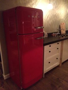 a red refrigerator freezer sitting next to a kitchen counter