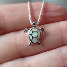 This is a very beautiful turtle necklace. It measures 1/2” long from the top of the jump ring, 1/2" wide and is solid sterling silver with inlaid white lab created opal. The pendant will come on a 1mm rounded box chain. The turtle symbolizes many things. Most of us know the story of the tortoise and the hare, reminding us that slow and steady wins the race. The turtle also symbolizes the earth, staying grounded, wisdom and emotional strength. An interesting fact about turtles is that they have b The Tortoise And The Hare, Turtle Facts, Tortoise And The Hare, Staying Grounded, Slow And Steady, Emotional Strength, White Lab, Turtle Charm, Turtle Necklace