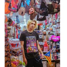 a young man standing in front of a store filled with hats and other items on display