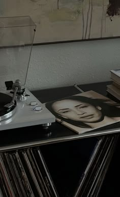 a record player sitting on top of a table next to a stack of vinyl records