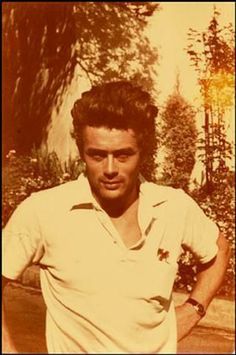 an old black and white photo of a man in tennis clothes posing for the camera