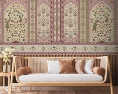 a couch sitting in front of a wall covered in intricately designed wallpapers