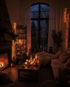 a living room filled with lots of candles next to a fire place in front of a window