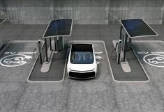 an electric car is parked in front of two charging stations with solar panels on them