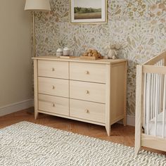 a baby's room with a crib and dresser