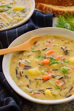 two bowls of soup with bread on the side