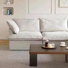 a living room with a couch, coffee table and pictures on the wall