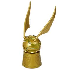 a golden harry potter replica on top of a gold cup with two wings flying over it