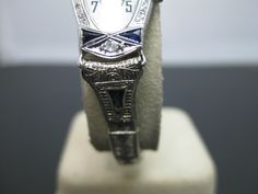 "PLEASE READ ENTIRE DESCRIPTION BEFORE PURCHASING For Sale: (1) Gorgeous Vintage 14k White Gold 1930s Vanburen Diamond & Sapphire Watch Please see pictures for more details! This is a gorgeous watch! The case is marked 14k on the inside. The movement is marked Vanburen Watch Swiss, 2 adjustments, 15 jewels. The watch case features two trillion sapphires at the 12 and 6 position. Above the sapphires is one .03 carat diamond. The watch band is marked 10k gold filled with a deployment clasp. Ea Art Deco Platinum Watch For Anniversary, Art Deco Platinum Anniversary Watch, Antique Platinum Watches For Anniversary, Antique Platinum Watch For Gift, Antique Platinum Watches As Gift, Antique Platinum Watches For Gifts, Antique Platinum Watches Suitable For Gifts, Art Deco Diamond Watch For Anniversary, Platinum Art Deco Watch For Formal Occasions