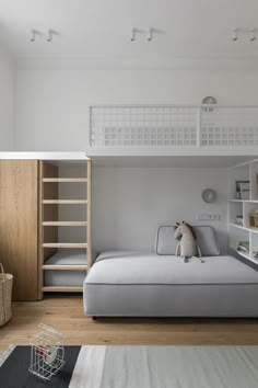 there is a loft bed in the middle of this room with bunk beds and bookshelves