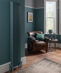 a living room with a chair and radiator next to a window in the corner