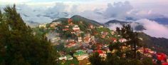 the city is surrounded by trees and clouds