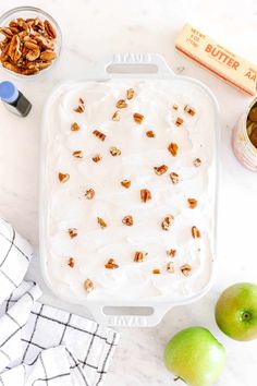 an ice cream dish with pecans and apples next to it