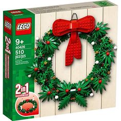 a christmas wreath made out of legos on top of a wooden wall next to a box