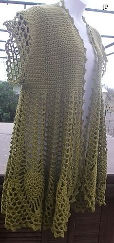 a crocheted shawl is on display in front of a window