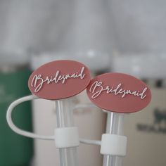 two pink buttons with the words bridal and bridesmaid written on them are plugged into a charger