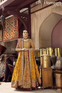 a woman in a yellow dress standing next to some rugs