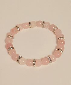 Rose quartz is known as the stone of love and reconcilliation and it is customary used as a gift of love.   It is thought to make one open to love and compassion.  Some believe that rose quartz has calming effects and helps to develope strong friendships. This  stretch bracelet consists of 8 mm genuine rose quartz beads with rhinestone embellished silver spacers. Rose quartz is typically a cloudy translucent pink colour.  The delicate colour of pink with silver makes for an ideal gift, which is sure to please the recipient. Pink And Silver Bracelet, Elegant Rose Quartz Pink Crystal Bracelet, Adjustable Rose Quartz Rose-colored Jewelry, Pink Rose Quartz Round Stretch Bracelet, Rose Quartz Round Crystal Bracelet Gift, Pink Rose Quartz Bracelet For Meditation, Pink Rose Quartz Bracelets For Meditation, Elegant Rose Quartz Healing Bracelets, Adjustable Rose Quartz Jewelry In Rose Color