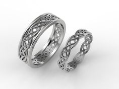 two wedding bands with intricate designs on each side, set against a plain white background