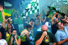 a group of people standing next to each other holding green and white checkered flags