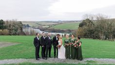 a group of people standing next to each other in front of a lush green field