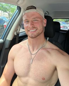 a shirtless man sitting in the back seat of a car