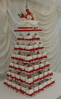 a very large cake that is on top of a table with red ribbon around it