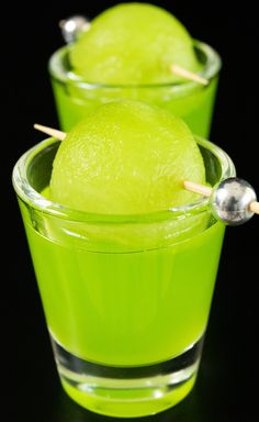 two glasses filled with green liquid and toothpicks