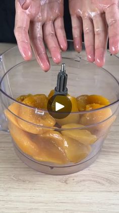 two hands are using a blender to make fruit