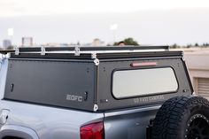 the back end of a silver truck parked on top of a parking lot