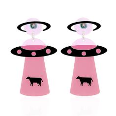 pair of pink and black earrings with cow on it's ear ends in the shape of an alien ship