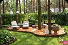 a wooden deck in the middle of a garden with two chairs and a table on it