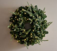 a wreath with lights hanging on the wall