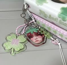 a keychain with a photo on it and a clover charm attached to it