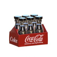 six coca - cola bottles are in a red display case on a white background,